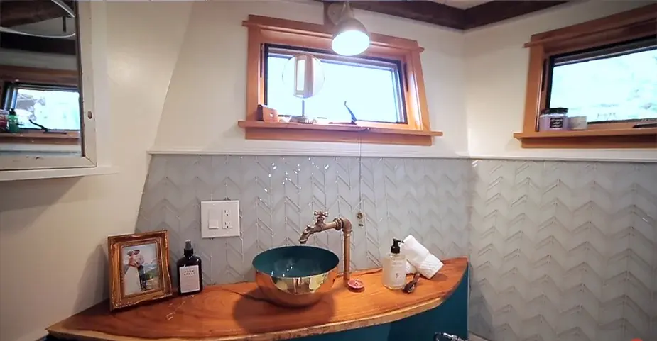0253 Tiny house with reclaimed materials bathroom penny floor smallhometours.com 4