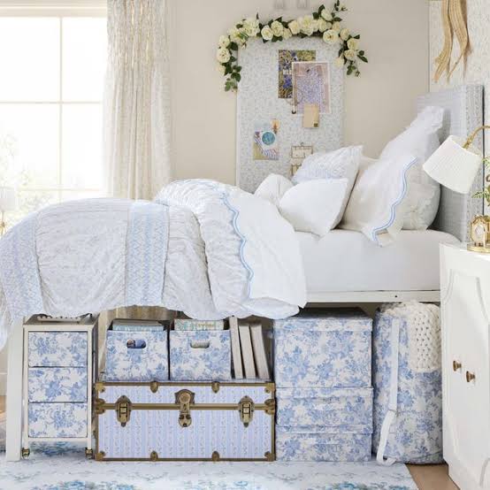 Bright bedroom with decorative storage trunks and boxes neatly tucked underneath the bed.