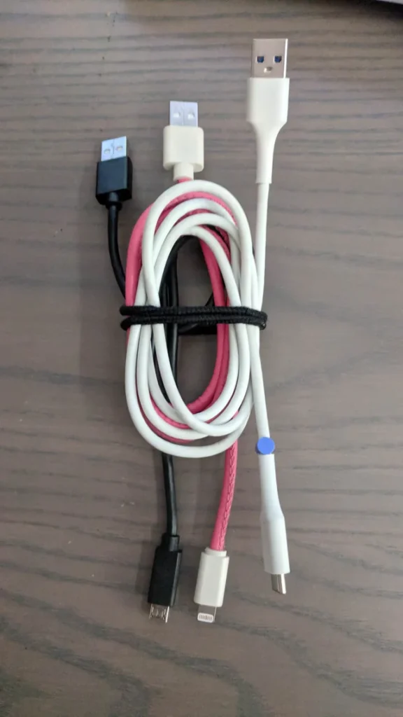 Black, pink, and white charging cables bundled together with a reusable cable tie.