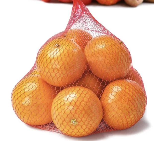Several oranges contained in a red mesh produce bag against a white background.