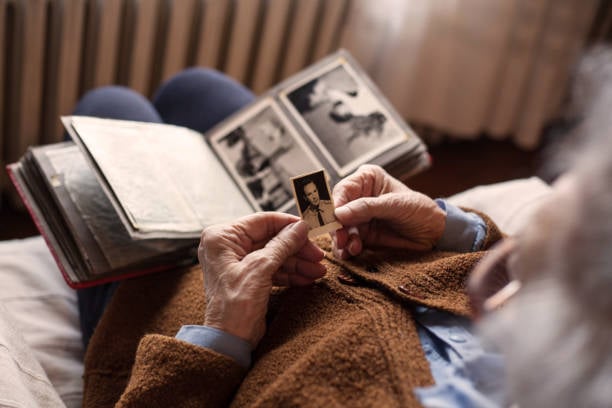 Senior adult woman looking at an old photo of her husband.