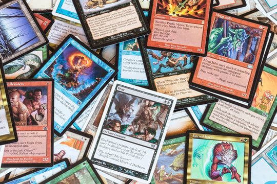 Assorted fantasy-themed trading cards spread across a surface in an overlapping pile.
